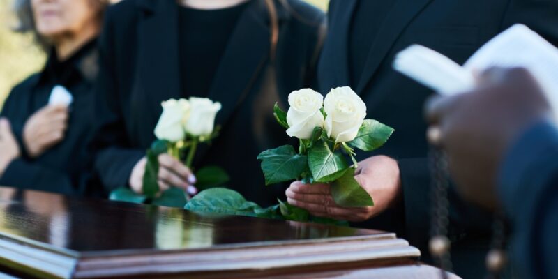 Focus,On,Two,Fresh,White,Roses,Held,By,Mourning,Man