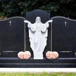 Blank,Elaborate,Gravestones,With,Jesus,Figure,In,Between,And,Flowers